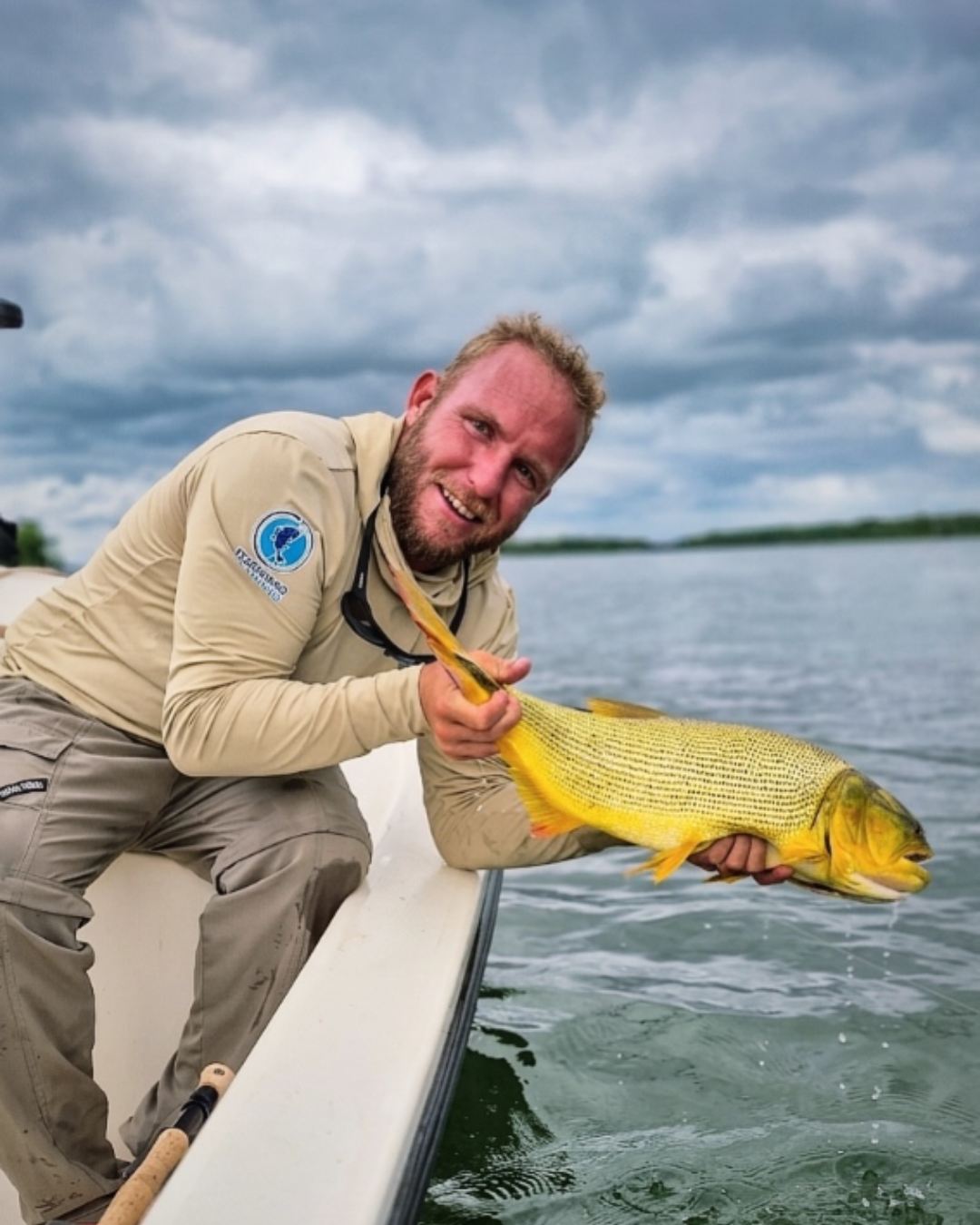 Guía sosteniendo un dorado recién pescado en el río Paraná